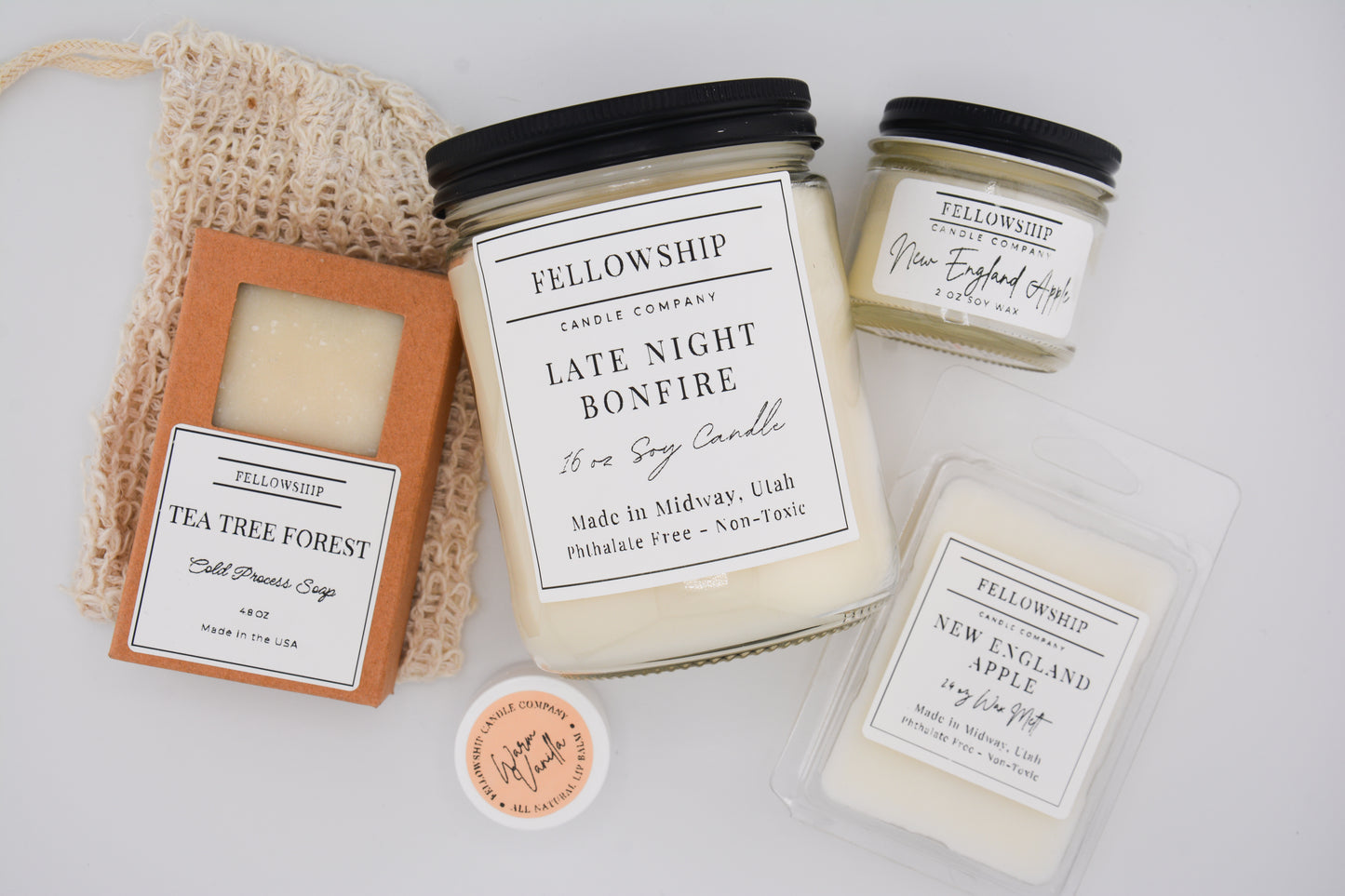Collection of candles and products from Fellowship Candle Company on a light background