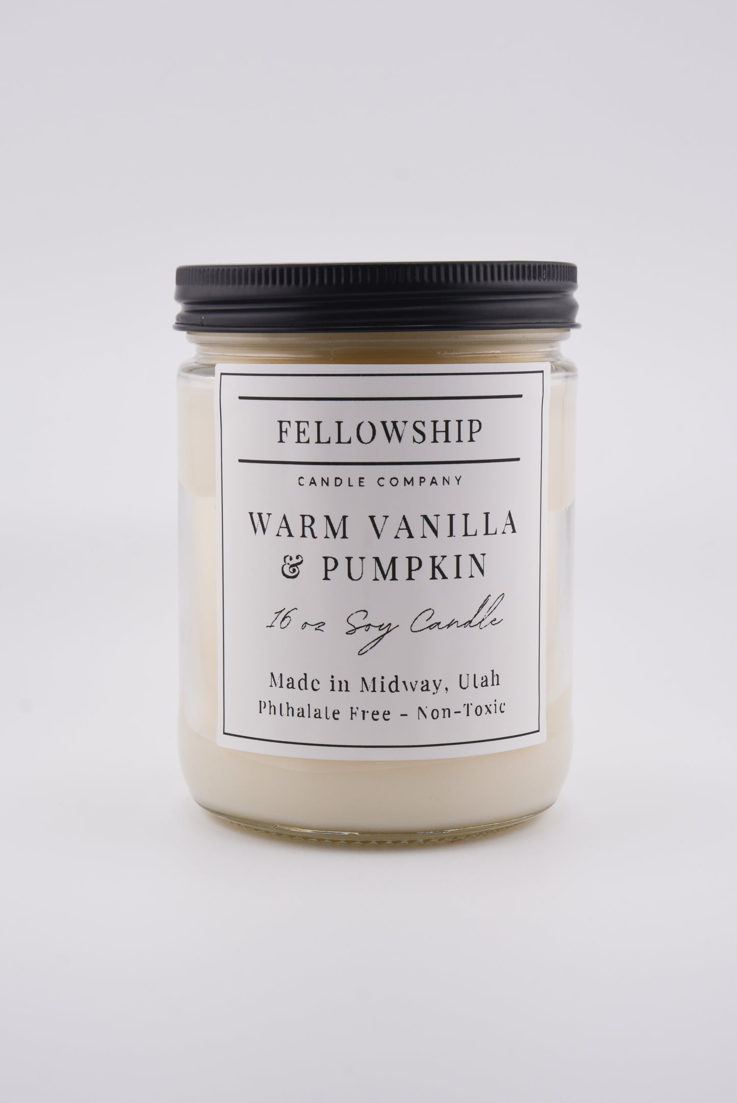 Candle jar labeled 'Fellowship Candle Company' with 'Warm Vanilla & Pumpkin' scent on a white background