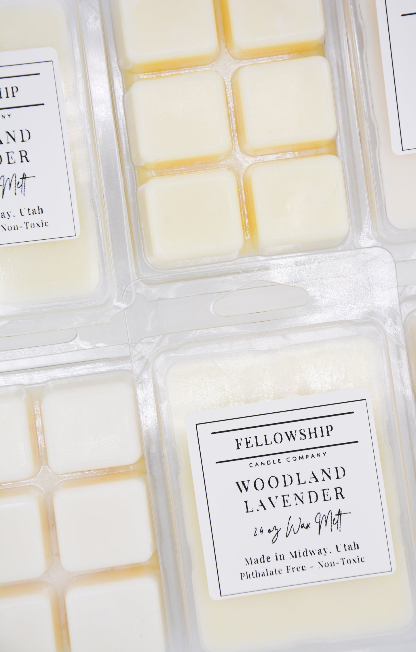 Packaged candles with 'Fellowship Candle Company' labels on a white background