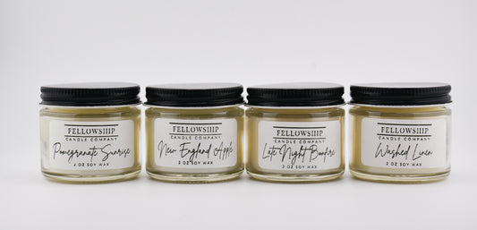 Four candles from Fellowship Candle Company on a white background