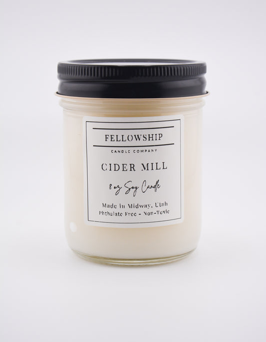 Candle jar labeled 'Fellowship Candle Company Cider Mill' on a white background