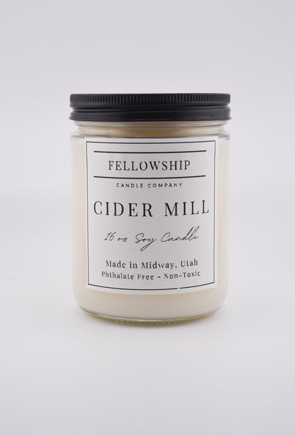 Candle jar labeled 'Fellowship Candle Company Cider Mill' on a white background