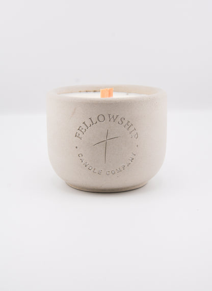 Concrete candle jar with 'Fellowship Candle Company' branding on a white background
