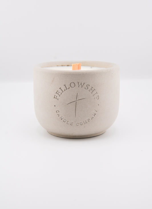 Concrete candle jar with 'Fellowship Candle Company' branding on a white background