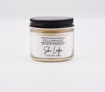 Candle jar with black lid and 'Fellowship Candle Company' label on a white background