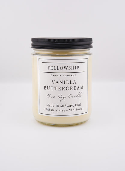 Vanilla buttercream candle with black lid on a white background