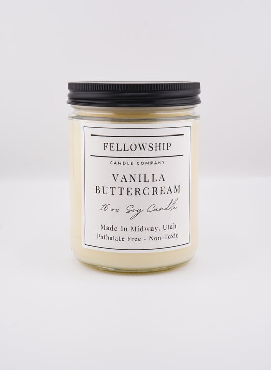Vanilla buttercream candle with black lid on a white background