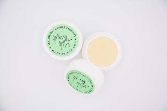 Two lip balm containers with green labels on a white background